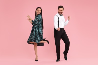 Photo of Happy couple dancing together on pink background