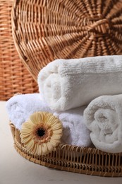 Photo of Rolled terry towels and flower on white table