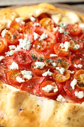 Tasty galette with tomato, thyme and cheese (Caprese galette) as background, closeup