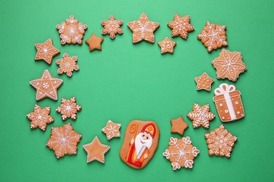 Frame of tasty gingerbread cookies on green background, flat lay with space for text. St. Nicholas Day celebration