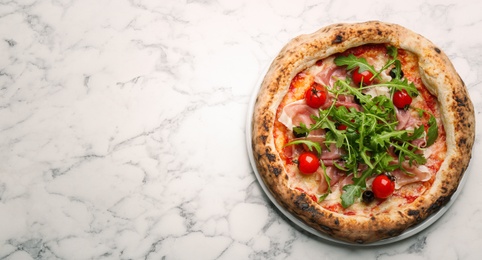 Photo of Tasty pizza with meat and arugula on white marble table, top view. Space for text