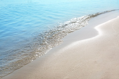 Photo of View of sea water and beach sand on sunny summer day