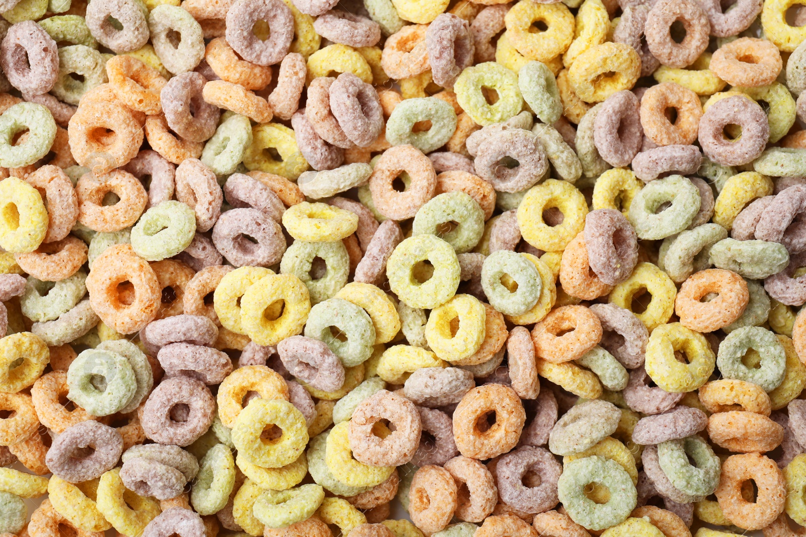 Photo of Tasty cereal rings as background, top view