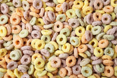 Photo of Tasty cereal rings as background, top view