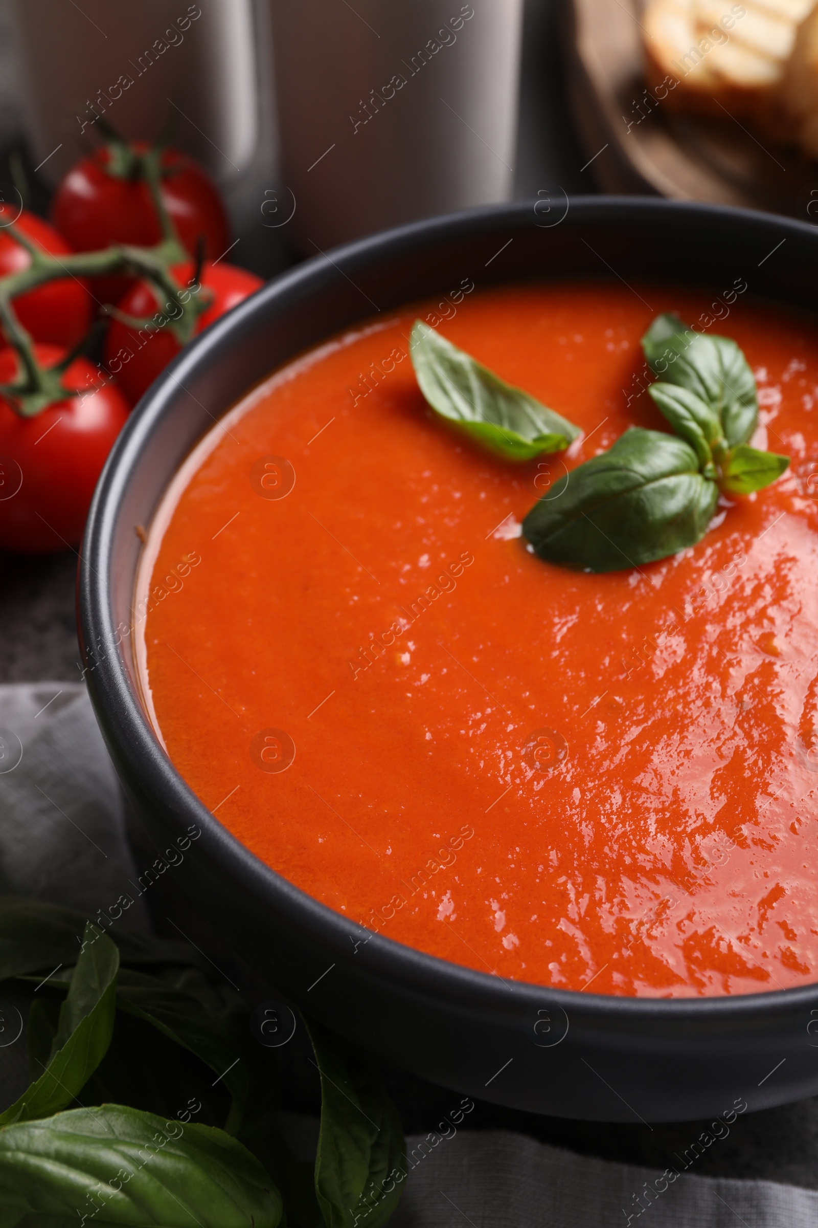 Photo of Delicious tomato cream soup in bowl on table, closeup