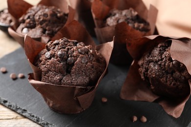 Delicious chocolate muffins on table, closeup view