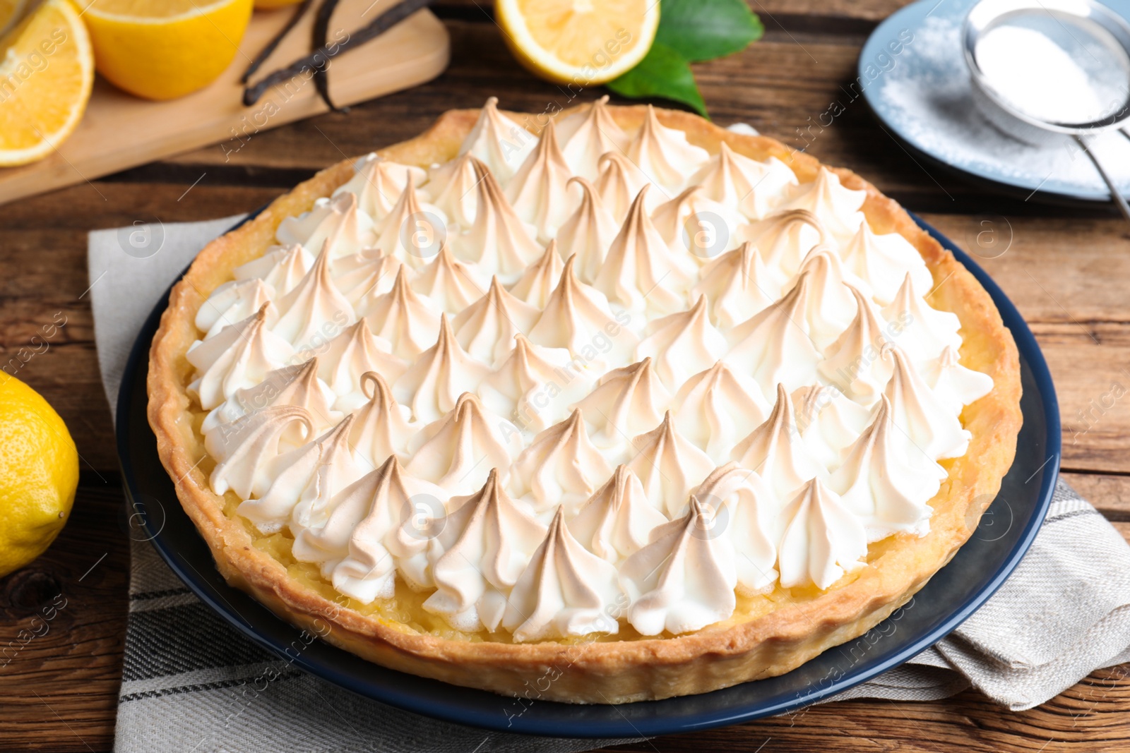 Photo of Delicious lemon meringue pie on wooden table, closeup