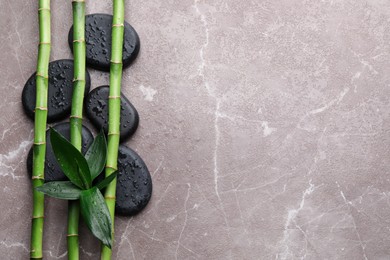 Photo of Wet spa stones and bamboo on grey marble table, flat lay. Space for text