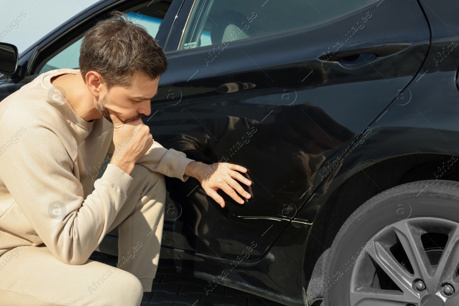 Photo of Stressed man near car with scratch outdoors