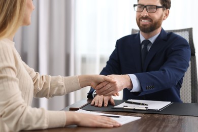 Photo of Lawyer shaking hands with client in office, selective focus