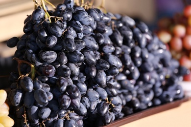 Photo of Fresh ripe juicy grapes on tray, closeup