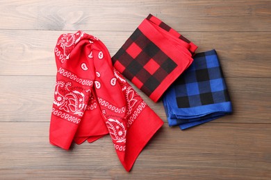 Photo of Stylish bandanas with different patterns on wooden table, flat lay