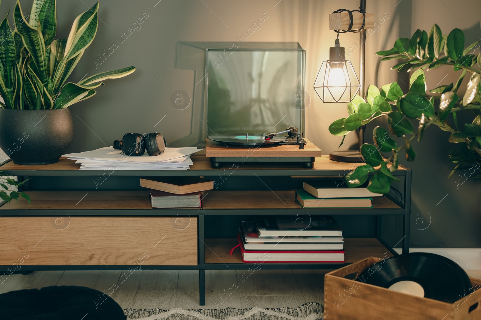 Photo of Stylish turntable with vinyl record on tv table in cozy room