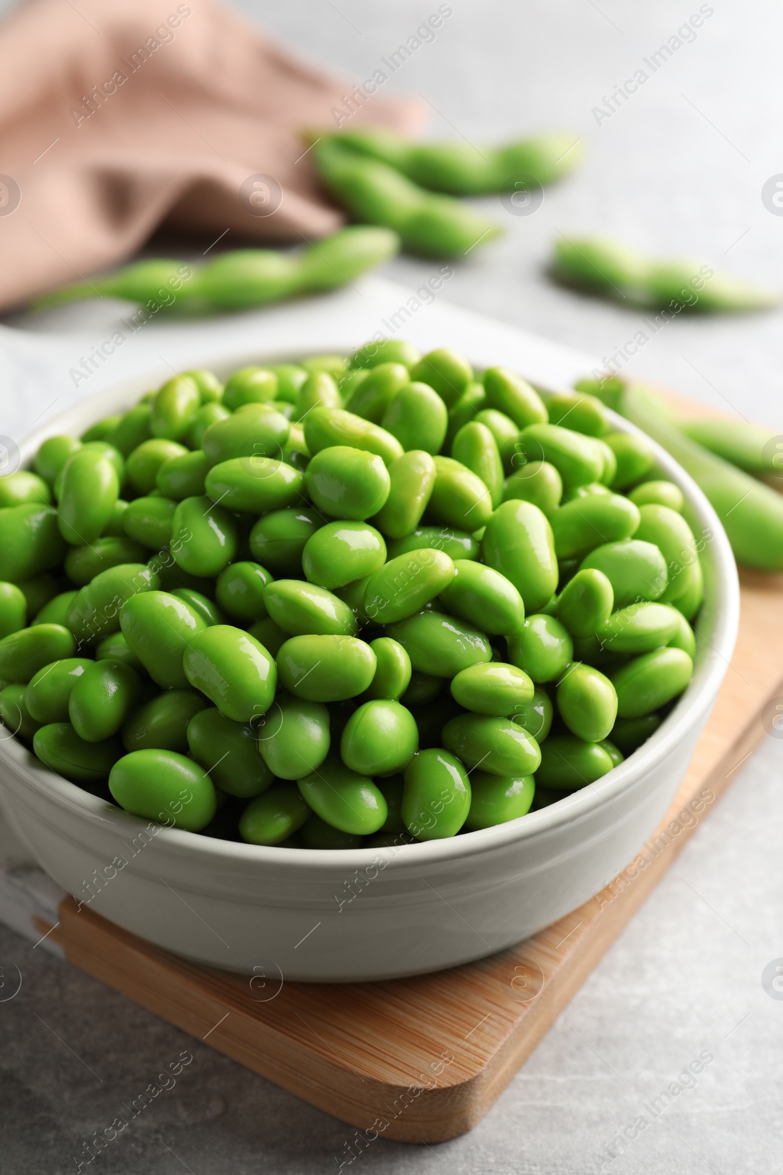 Photo of Bowl of delicious edamame beans on table, closeup