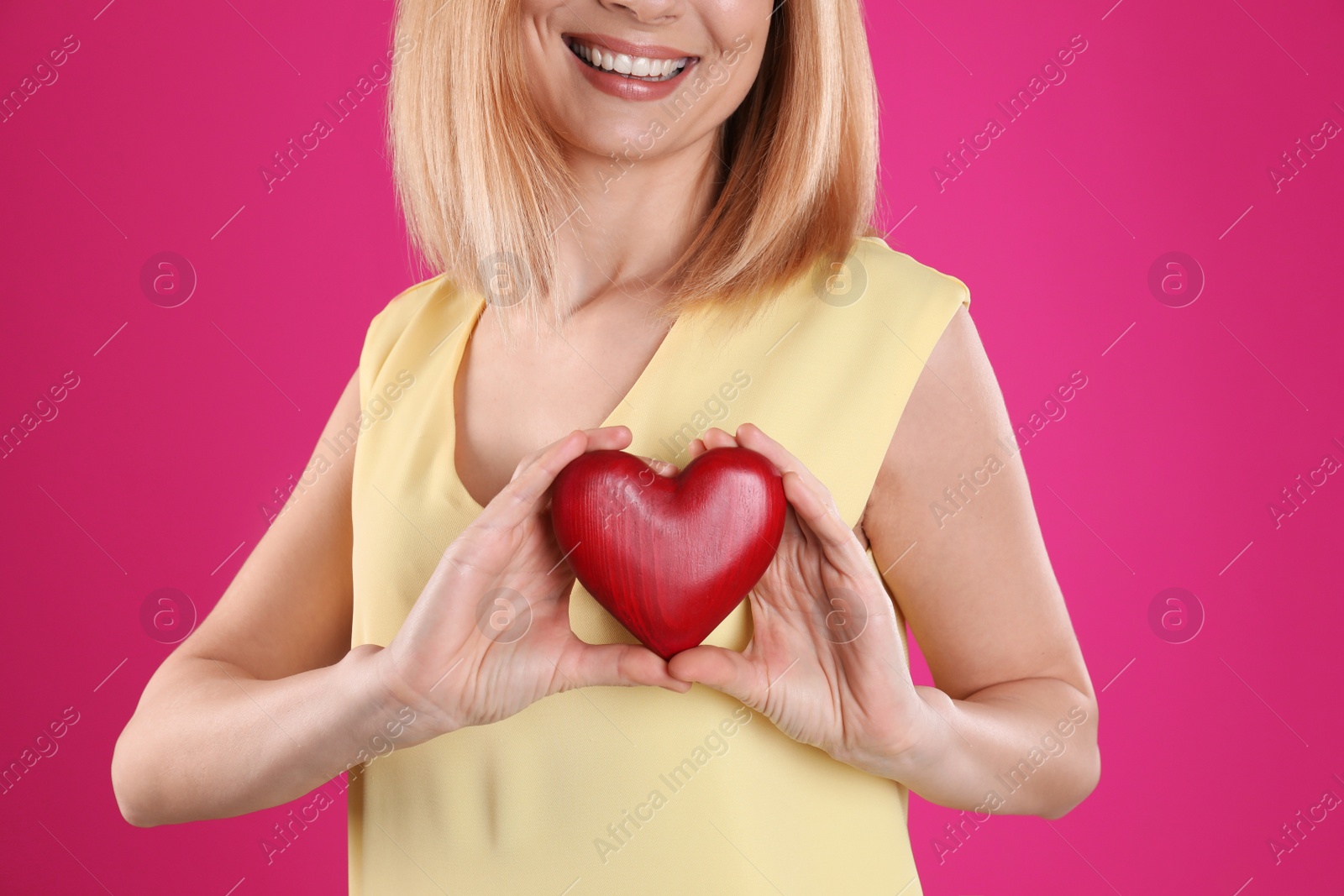 Photo of Woman holding decorative heart on color background, closeup