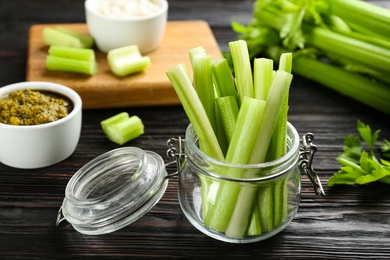 Celery sticks in jar on dark wooden table