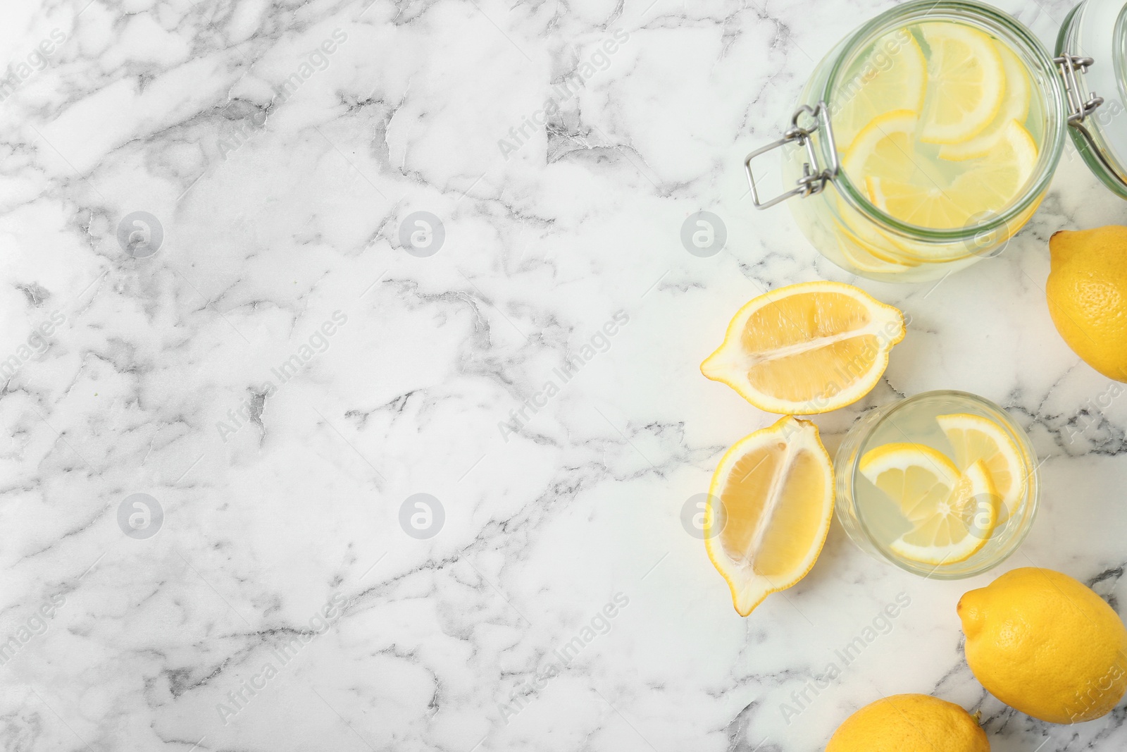 Photo of Flat lay composition with delicious natural lemonade on marble background