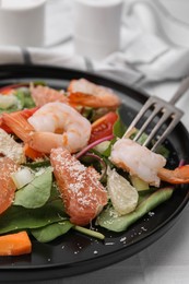 Delicious salad with pomelo, shrimps and tomatoes on white tiled table, closeup