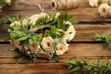 Photo of Composition with wreath made of beautiful flowers on wooden table