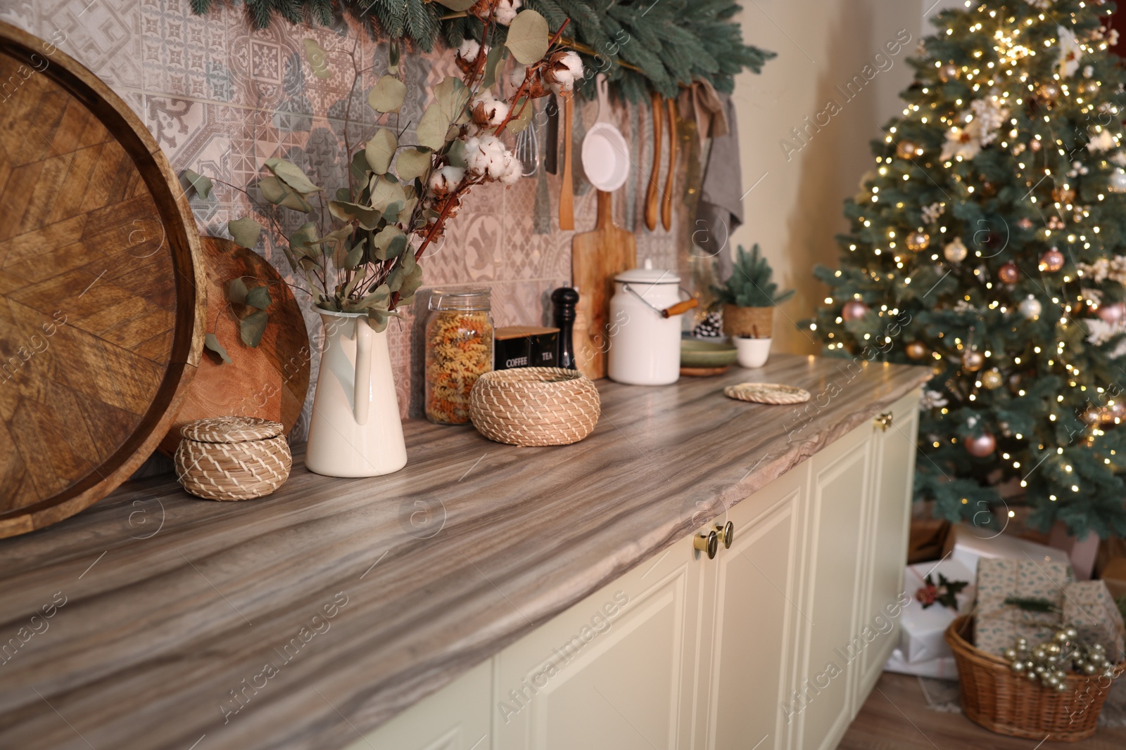 Photo of Stylish kitchen with festive decor and Christmas tree. Interior design