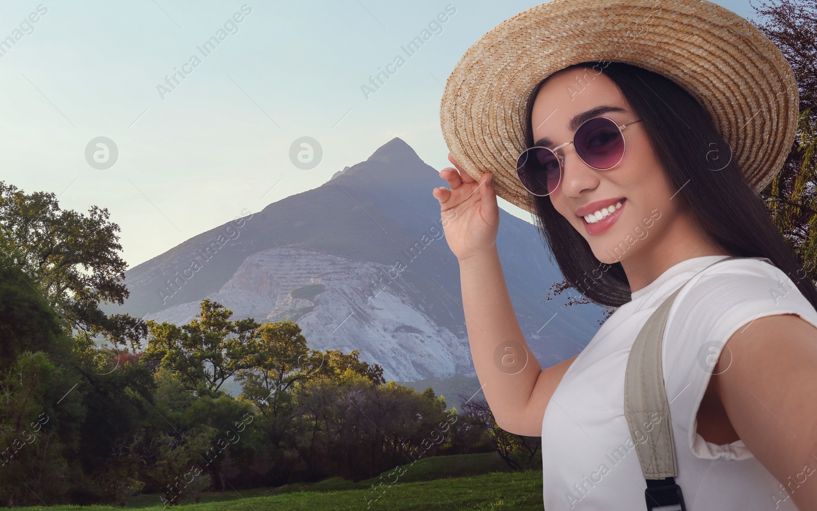 Image of Beautiful woman in straw hat taking selfie in mountains