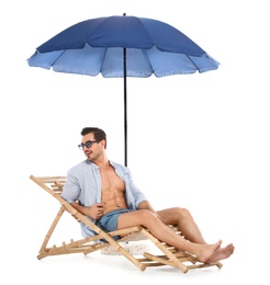 Young man on sun lounger under umbrella against white background. Beach accessories