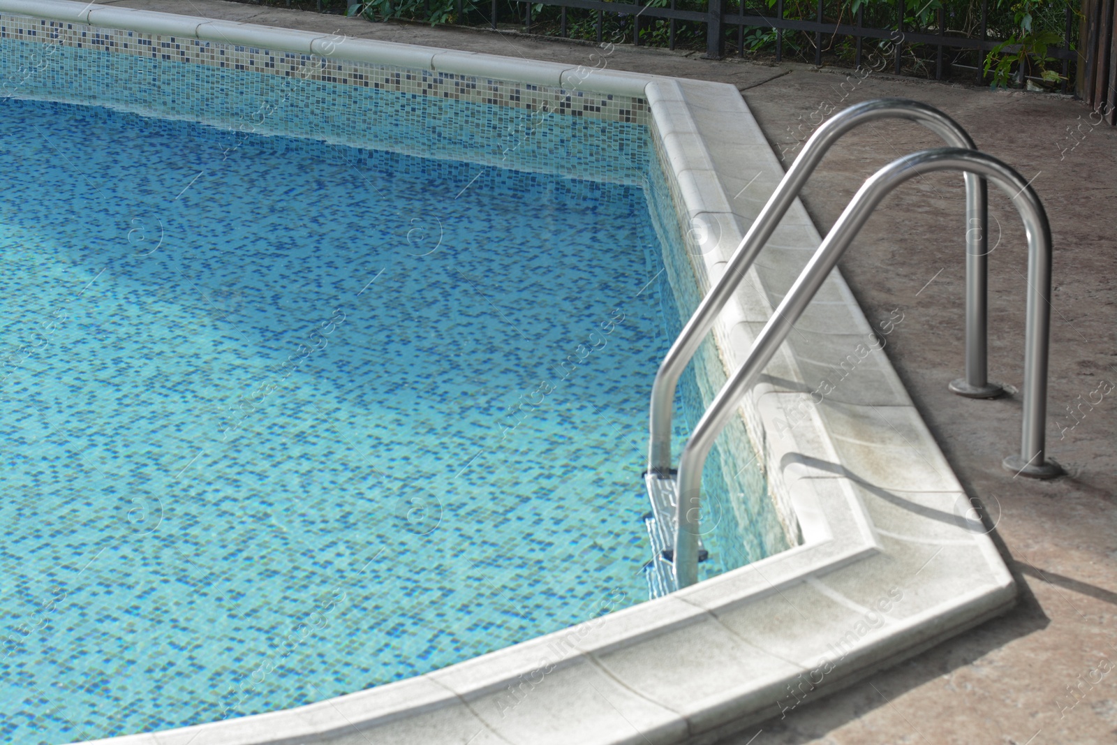 Photo of Ladder with grab bars in outdoor swimming pool