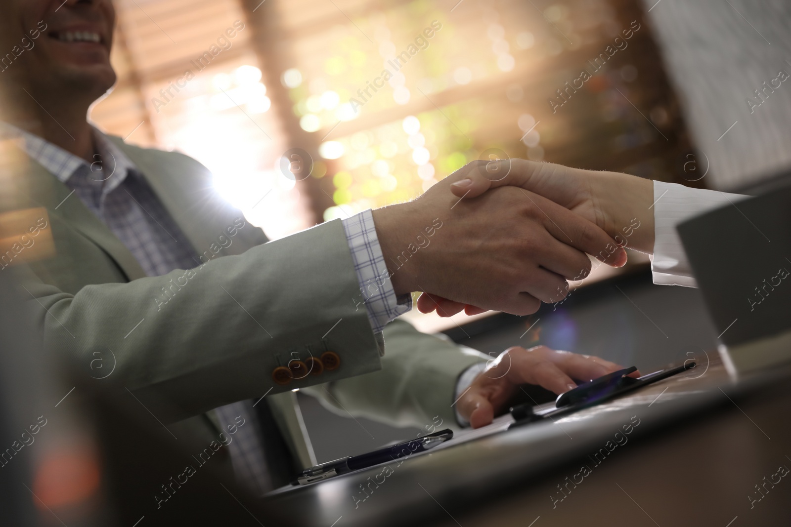 Photo of Business people shaking hands in office, closeup