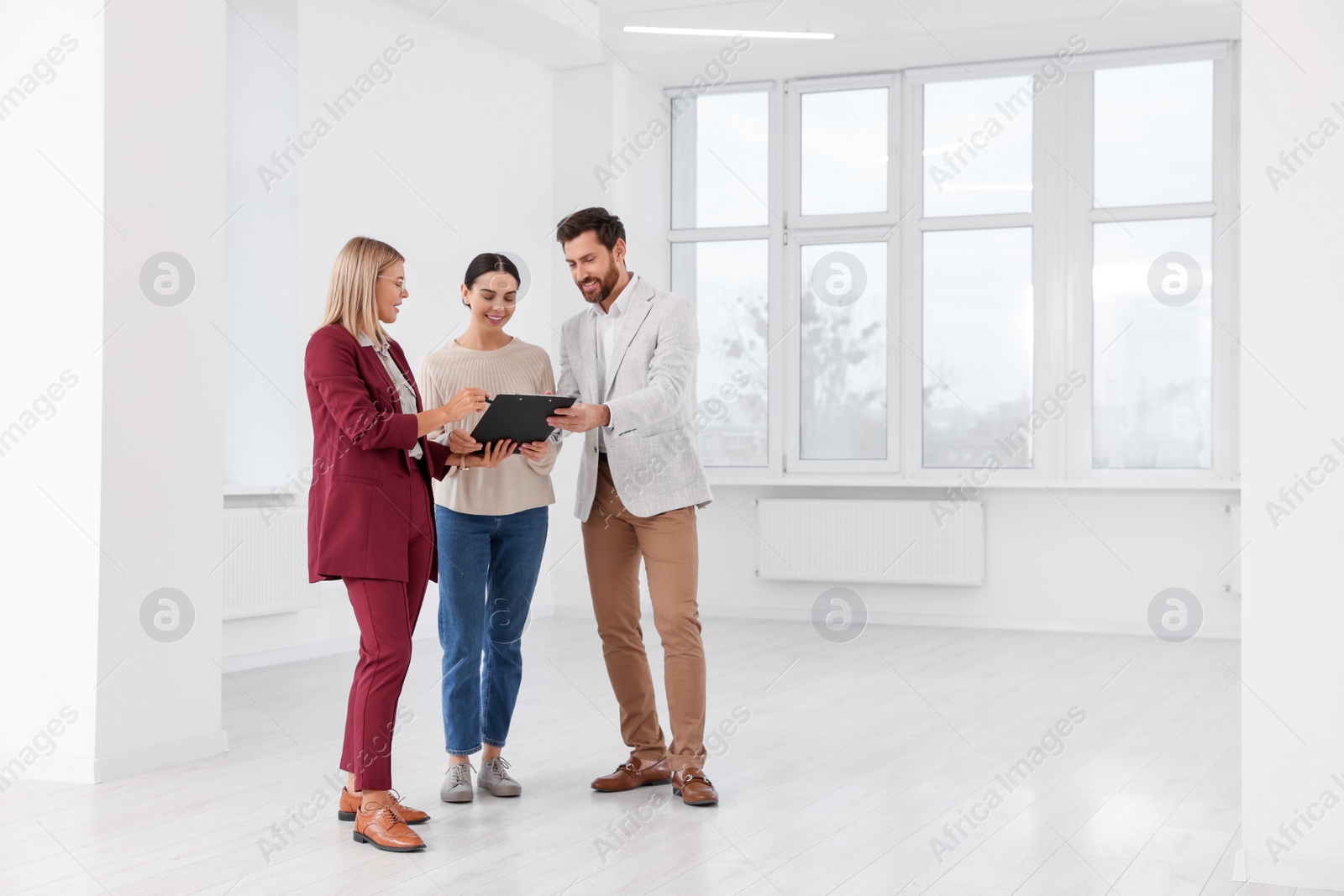 Photo of Real estate agent showing new apartment to couple