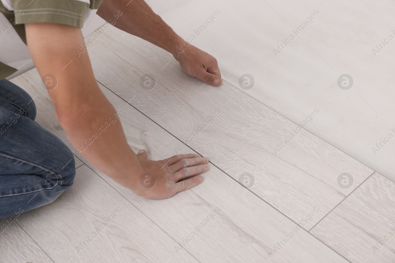 Photo of Professional worker installing new laminate flooring, closeup