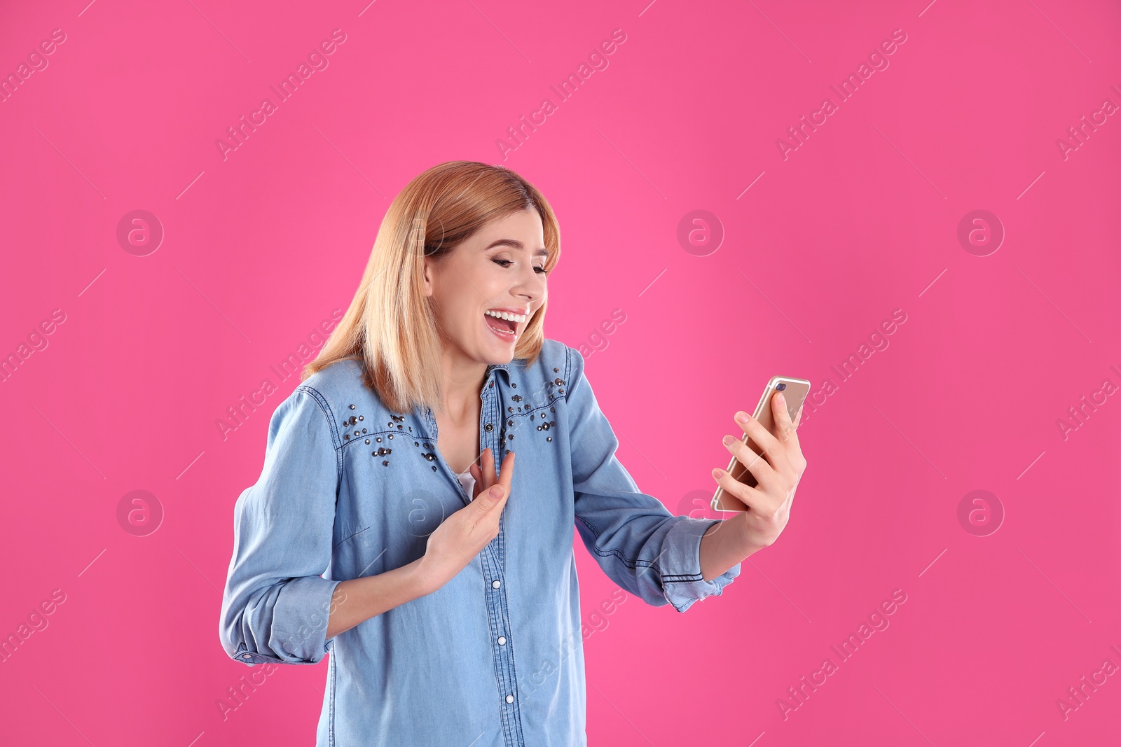 Photo of Woman using mobile phone for video chat on color background