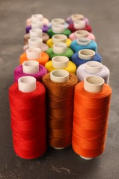 Photo of Set of color sewing threads on grey table