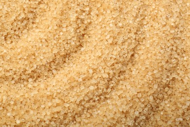 Photo of Granulated brown sugar as background, top view