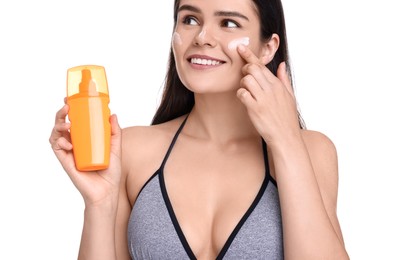 Beautiful young woman holding bottle of sun protection cream on white background