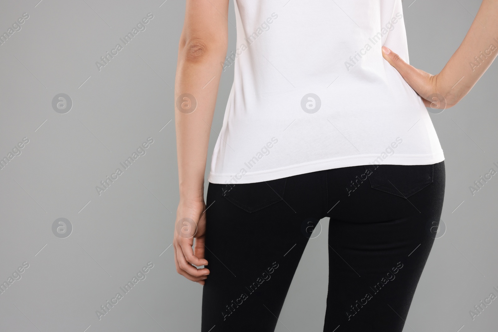 Photo of Woman wearing stylish black jeans on light gray background, closeup. Space for text