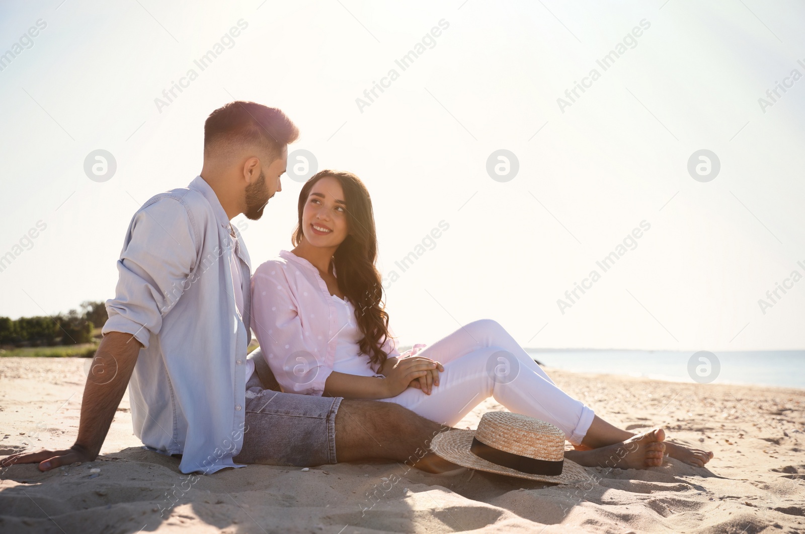 Photo of Happy young couple on beach near sea. Honeymoon trip