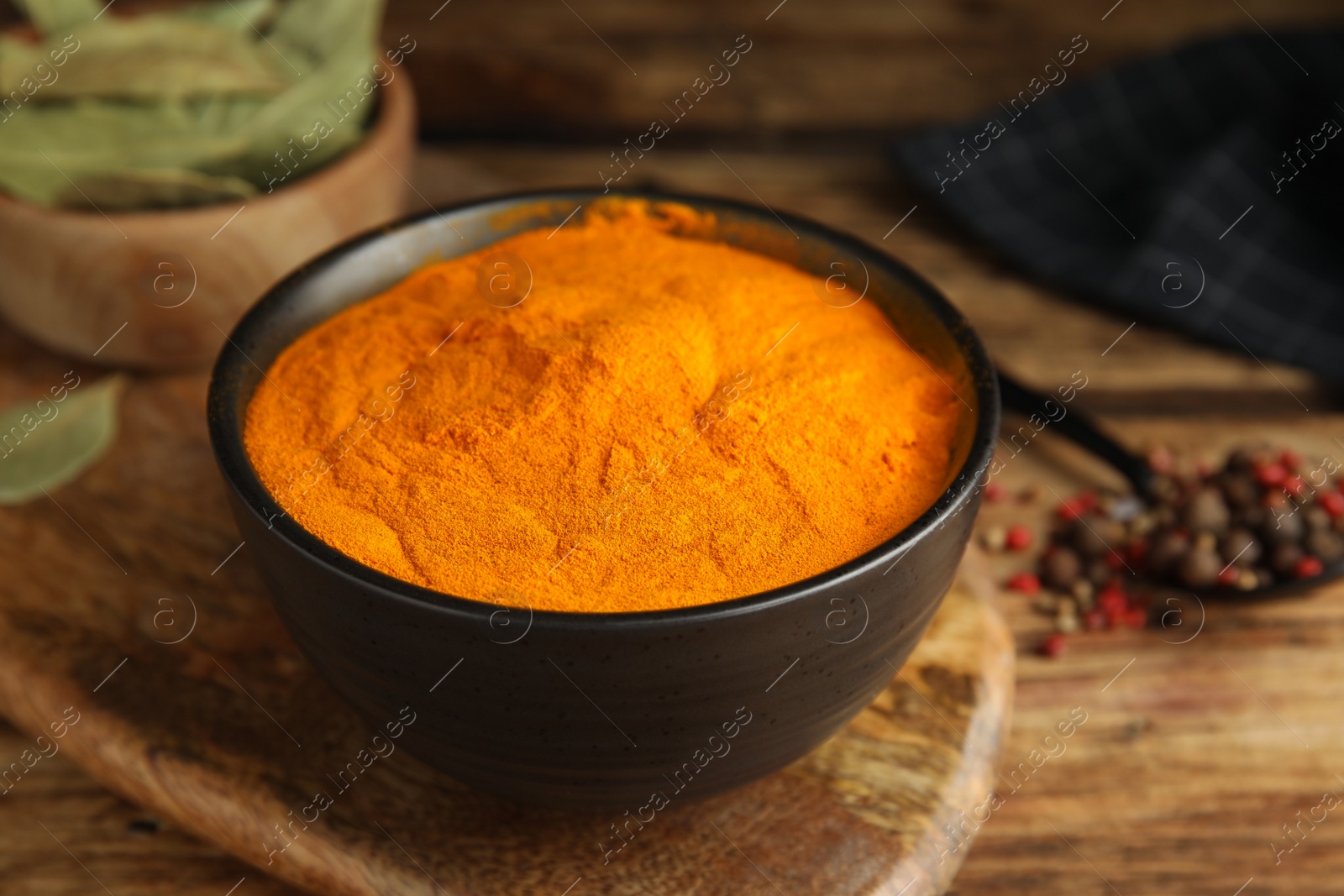Photo of Aromatic saffron powder in bowl on wooden table