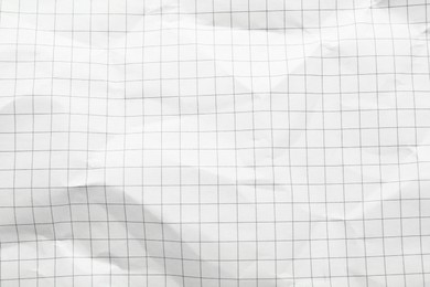 Crumpled checkered notebook sheet as background, top view