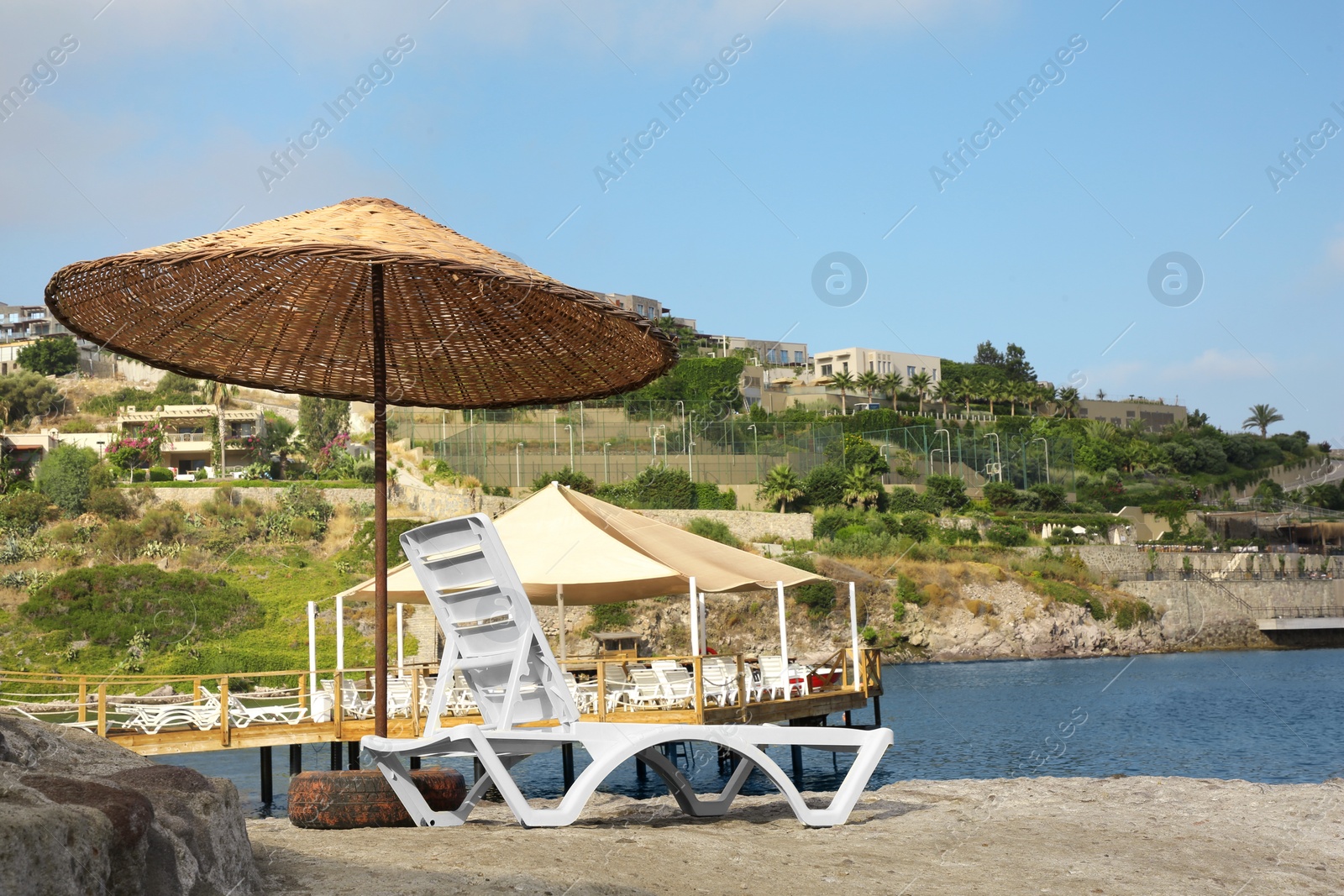 Photo of Lounge chair and beach umbrella on sea shore