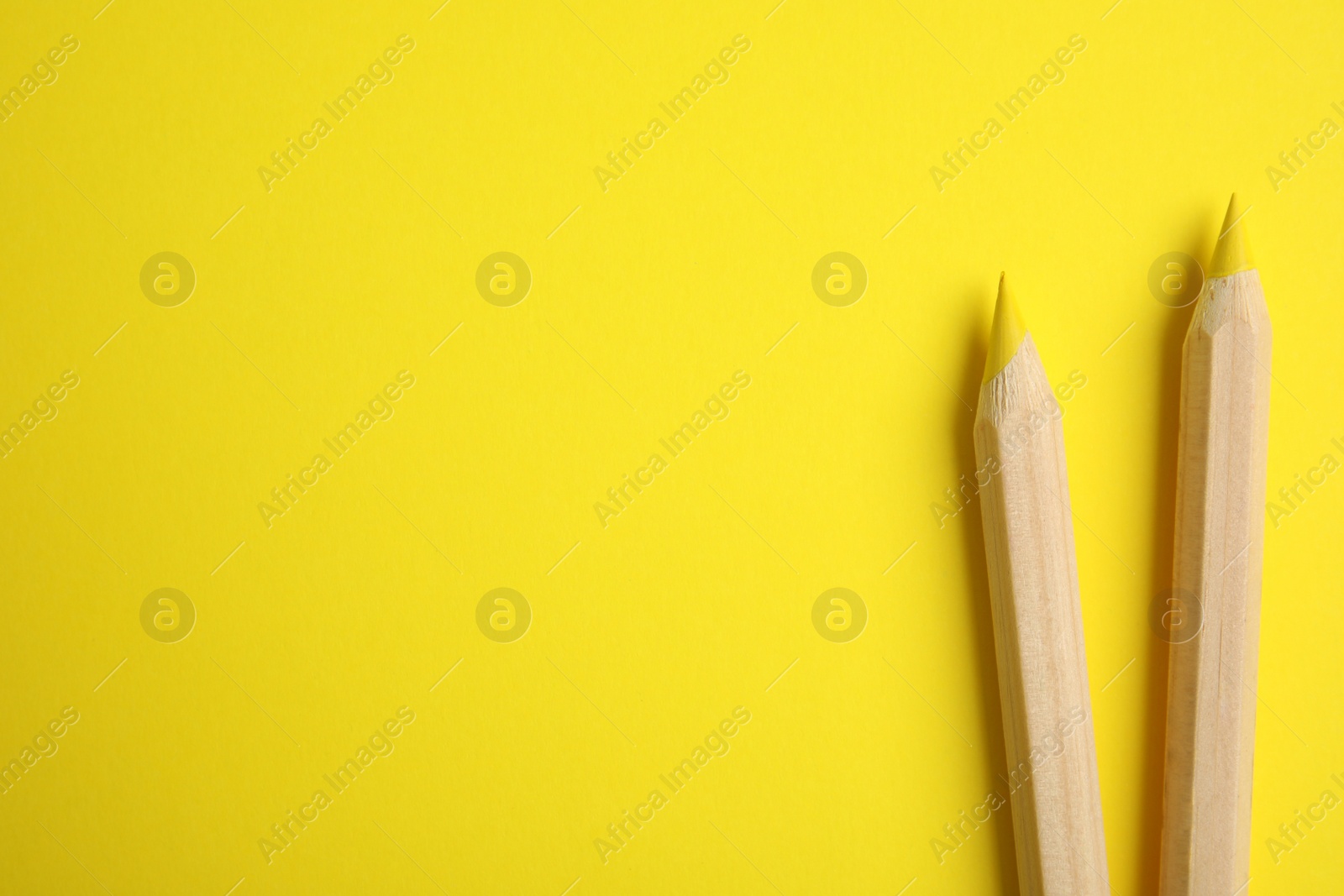 Photo of Flat lay composition with color pencils on yellow background, space for text