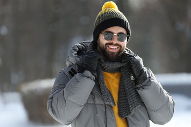 Portrait of handsome young man with sunglasses on winter day outdoors
