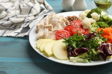 Photo of Balanced diet and healthy foods. Plate with different delicious products on blue wooden table, closeup