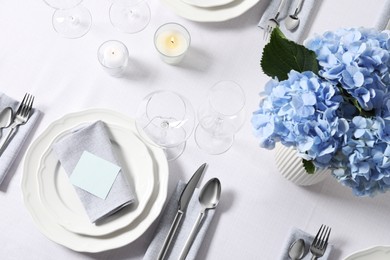 Photo of Beautiful table setting with blank card and floral decor, flat lay