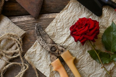 Flat lay composition with old secateurs and other gardening tools on wooden table