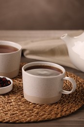 Aromatic tea and dry flower petals on wooden table