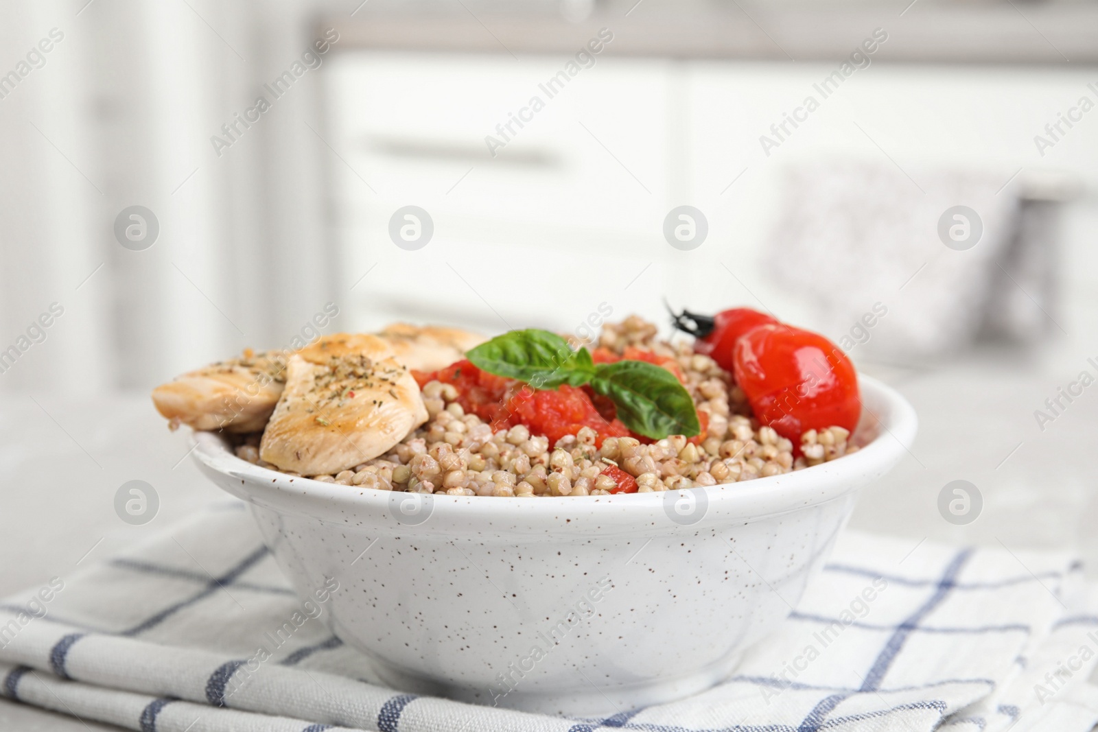 Photo of Tasty buckwheat porridge with meat on table indoors