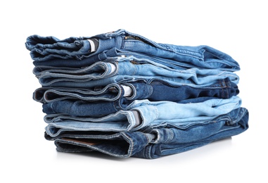 Stack of stylish jeans on white background