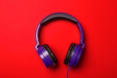 Photo of Stylish modern headphones on color background, top view