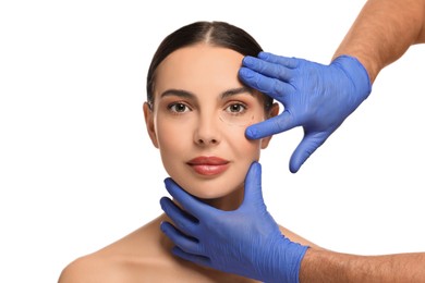Photo of Doctor checking patient's face before cosmetic surgery operation on white background