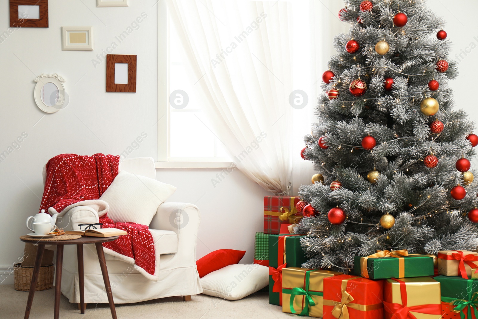 Photo of Stylish room interior with beautiful Christmas tree and gift boxes